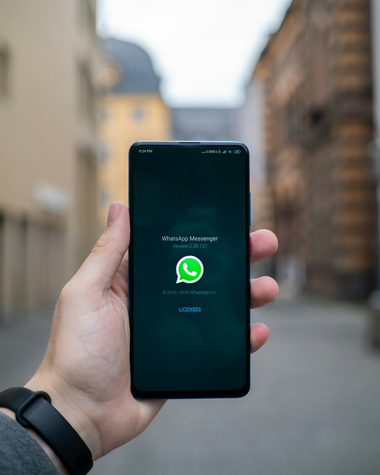 Person holding a smartphone showing a messaging app — illustration for an article about a Chrome extension to find unanswered WhatsApp chats