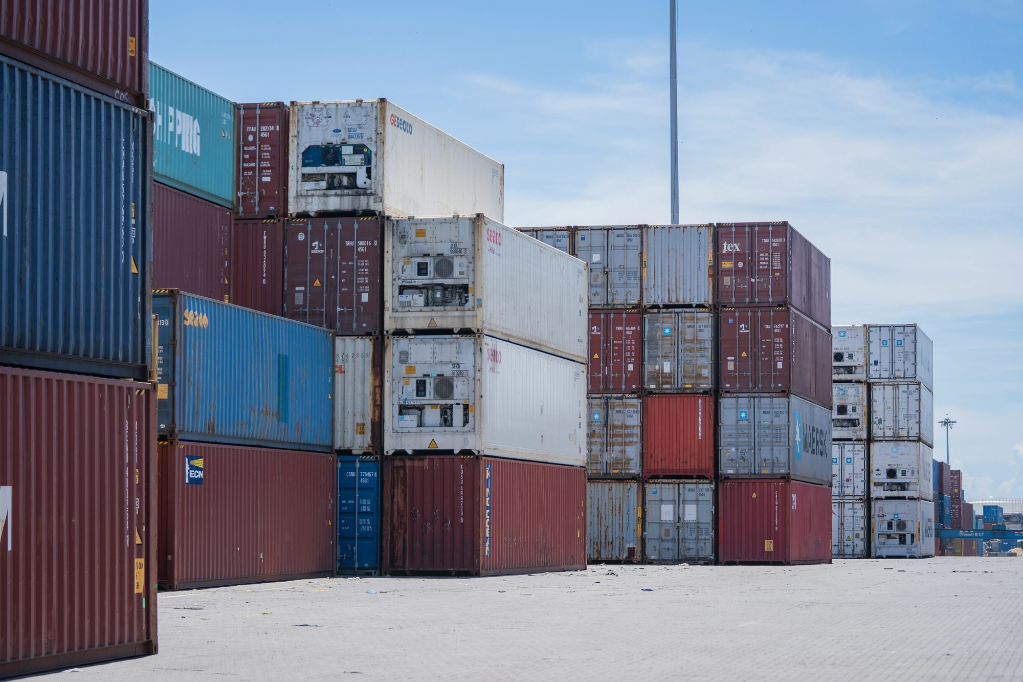 pgvector docker compose : piles de conteneurs dans un port sous un ciel bleu