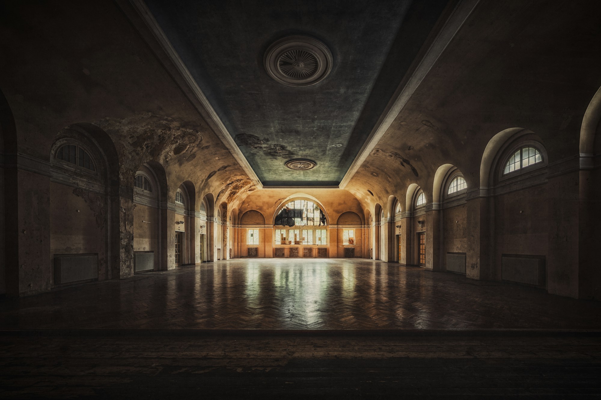 ancienne salle de bal vide, parquet éclairé au fond